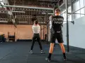 Para ćwiczy z kettlebell w siłowni CrossFit.